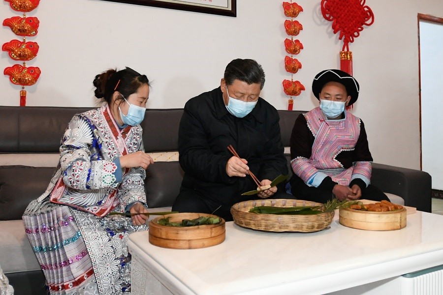 2021年2月3日下午，習(xí)近平在貴州畢節(jié)市黔西縣新仁苗族鄉(xiāng)化屋村苗族村民趙玉學(xué)家，同一家人邊聊家常邊制作當(dāng)?shù)貍鹘y(tǒng)節(jié)日食品黃粑。新華社記者 李學(xué)仁 攝