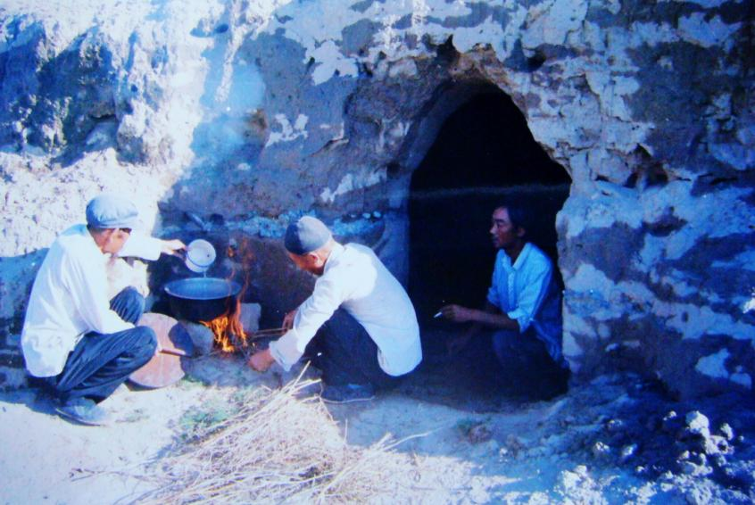 1983年，“六老漢”一代治沙人在“地窩子”生活做飯。新華社發(fā)（八步沙林場供圖）